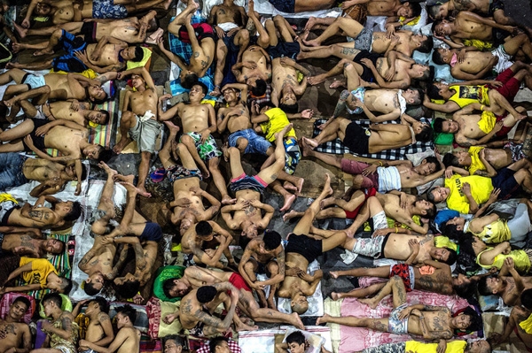 
Các tù nhân ngủ trên mặt đất của một sân bóng rổ bên trong nhà tù thành phố Quezon, Manila, Philippines. Có 3.800 tù nhân tại nhà tù này, nơi được xây dựng 6 thập kỉ trước để nhốt 800 tù nhân.