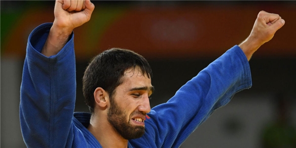  Vận động viên người Nga – Khasan Khalmurzaev và khoảnh khắc chạm tay đến huy chương vàng. (Ảnh: Cosmopolitan)