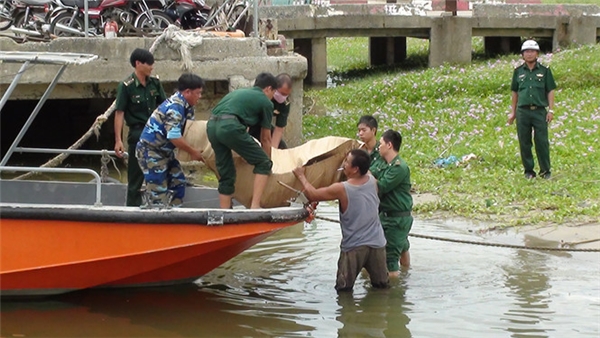 
Lực lượng biên phòng và người dân cùng đưa thi thể cô gái xấu số lên bờ. (Ảnh: Nguyễn Tú)