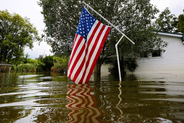 
Một lá cờ Mỹ đang bị ngập một phần trên dòng nước lũ nghiêm trọng ở Sorrento, Louisiana.