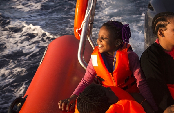 
Một bé gái di cư 9 tuổi tên Sira đến từ Nigeria đang nở nụ cười hạnh phúc trên con tàu RIB của Tổ chức phi chính phủ Proactiva Open Arms, ở vùng biển Địa Trung Hải, khoảng 17 dặm về phía bắc Sabratah, Libya. 