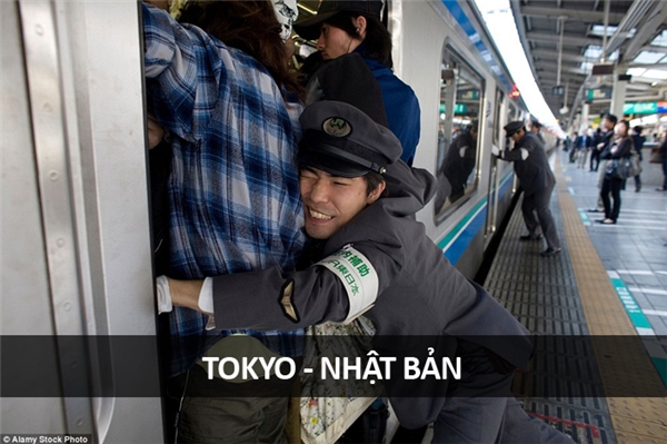
Tại một ga tàu điện ngầm cực kì đông đúc ở Tokyo, các nhân viên nhà ga phải “nhồi nhét” hành khách vào toa tàu trước khi tàu lăn bánh.