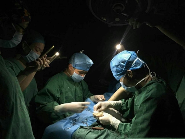 
Các bác sĩ trong bệnh viện dùng đèn flash điện thoại làm nguồn sáng cho ca phẫu thuật khi khu vực bị mất điện.