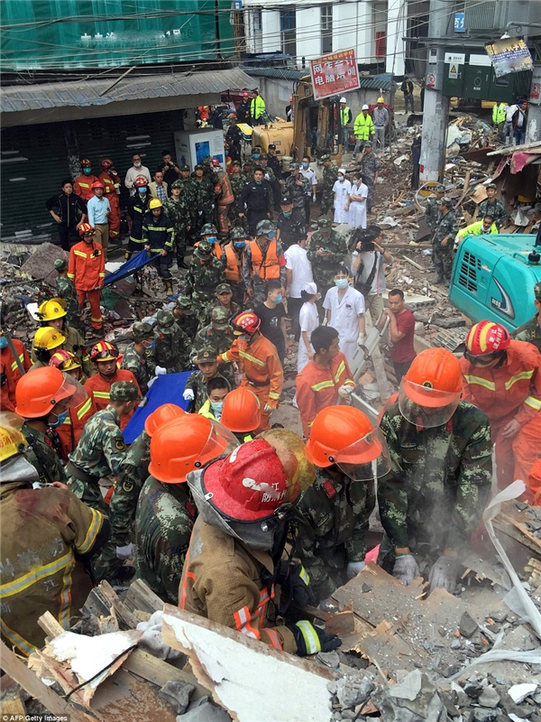 
Y tá, nhân viên cứu hộ, nhân viên cứu hỏa, cảnh sát và các cơ quan khác đứng xung quanh hiện trường của các tòa nhà sụp đổ.