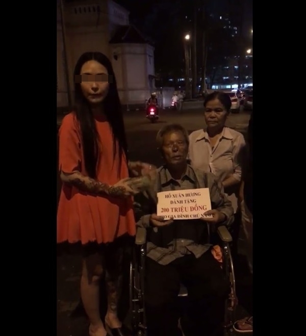 
Hình ảnh H.X.H trao tiền từ thiện cho gia đình chú Năm ngay giữa đường phố Sài Gòn. (Ảnh: Cắt clip)