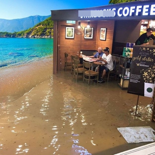 Cụ ông Hồng Kông thảnh thơi ngồi cà phê đọc báo bất chấp lũ lụt 