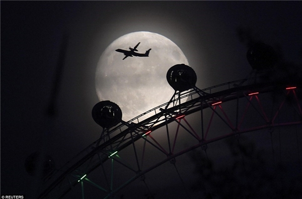  
Một phi cơ bay trên nền trời trăng rằm ở thủ đô London của Anh. (Ảnh: Reuters)