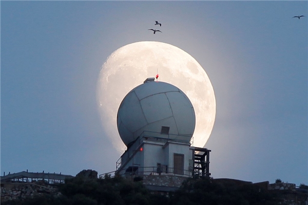   
Trăng rằm dần xuất hiện trên nóc một tháp quan sát tại vùng lãnh thổ Gibraltar của Anh. (Ảnh: Reuters)