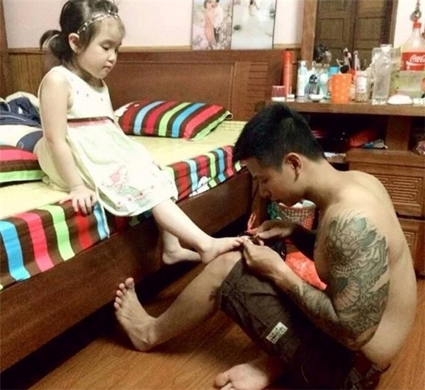 
Ông bố xăm trổ tỉ mỉ chăm sóc cho công chúa nhỏ. (Ảnh: Internet)