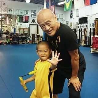 
Ryusei chụp ảnh bên cạnh thầy dạy võ của mình.
Cậu bé thường xuyên mặc bộ đồ vàng "huyền thoại" của Lý Tiểu Long trong lúc luyện võ.