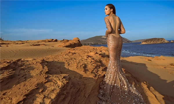 
Hoa hậu Kỳ Duyên như hòa làm một với không gian qua chiếc váy có màu vàng, nâu tượng trưng cho đất cát miền sa mạc.