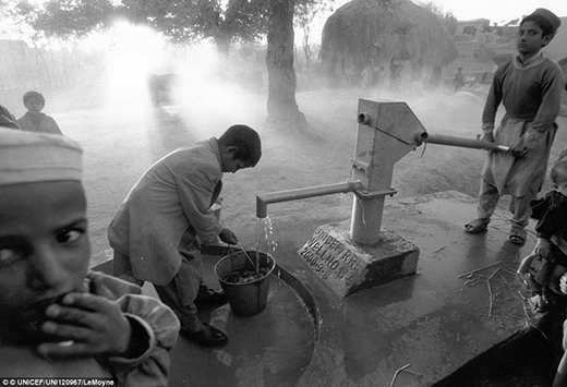 
Hai đứa trẻ đi lấy nước tại máy lấy nước bằng tay ở vùng ngoại ô thị trấn Laghman. 