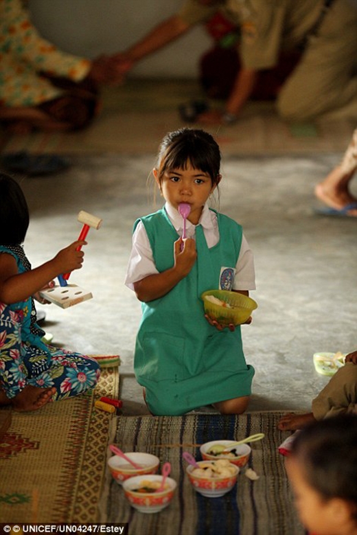 
Và một bé gái đang ăn thức ăn tại trung tâm sức khỏe cộng đồng ở quận Klaten, thị trấn Central Java. 