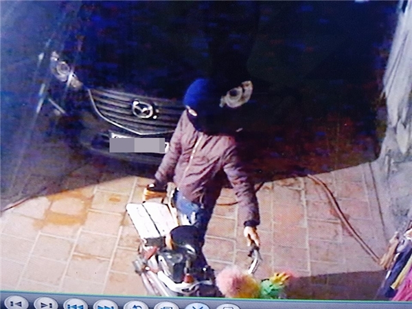 
Tên trộm di chuyển đồ đạc trong sân để lấy khoảng trống dắt xe máy ra ngoài.
