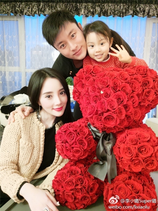 
Cặp sao khoe ảnh gia đình hai vợ chồng chụp cùng con gái Điềm Hinh bên những đóa hoa đỏ thắm.