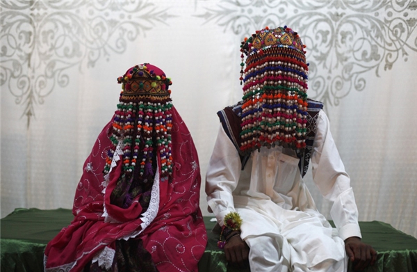 
Cô dâu ở Pakistan thường chọn những trang phục có màu đỏ, hồng và tím đậm. Cả cô dâu lẫn chú rể đều phải đội những chiếc mũ đính ruy băng phủ kín mặt.
