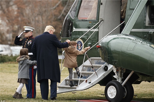 
Vị tổng thống giúp hai người cháu nhỏ đi lên máy bay.